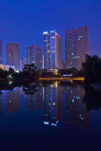 un perfil urbano por la noche con un cuerpo de agua en Radisson Blu Hotel Liuzhou, en Liuzhou