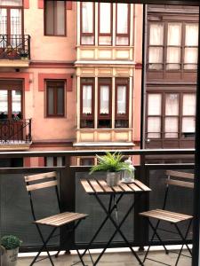 zwei Stühle und ein Tisch vor einem Gebäude in der Unterkunft El rincón de Valeria in Bilbao