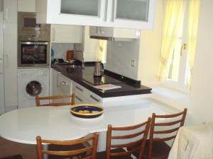 ブロトにあるApartamentos Vallesのキッチン(白いテーブル、椅子、シンク付)