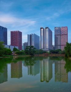 um horizonte da cidade com edifícios altos e um lago em Radisson Blu Hotel Liuzhou em Liuzhou