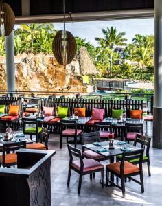 a restaurant with tables and chairs and a view of the ocean at Radisson Blu Resort Fiji in Denarau