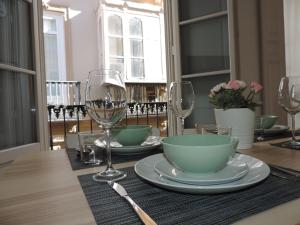 a table with two plates and wine glasses on it at Casita de Santos in Málaga