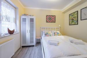 希維拉杜夫茲德魯伊的住宿－Apartament Kawowy - 5D Apartamenty，卧室设有一张白色大床和一扇窗户。
