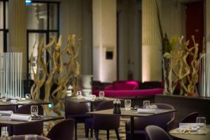 a restaurant with tables and chairs and a couch at Radisson BLU Hotel Nantes in Nantes