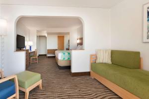 Habitación de hotel con sofá y cama en DoubleTree by Hilton Corpus Christi Beachfront, en Corpus Christi