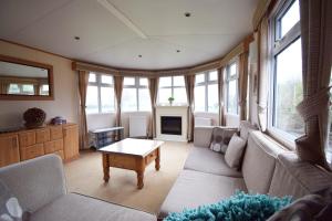 uma sala de estar com um sofá e uma mesa em Locatie Het Knooppunt Engelse Chalet em Nuis