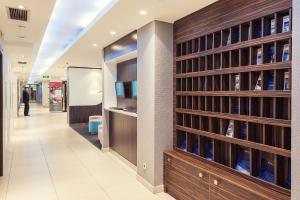 biblioteca con estanterías de madera y botellas de vino en Park Inn by Radisson Hotel Astana en Astaná