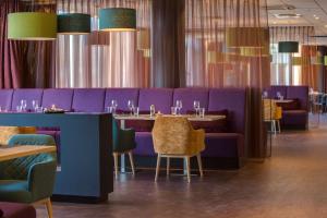 a restaurant with purple booths and tables and chairs at Radisson Blu Hotel Oslo Alna in Oslo +53 photos