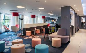 a lobby with a waiting area with chairs and tables at Park Inn by Radisson Hotel Astana in Astana