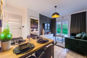 a living room with a wooden table and a couch at Apartament Izerska Przygoda - 5D Apartamenty in Świeradów-Zdrój