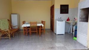 a kitchen with a table and chairs and a refrigerator at Casa Guaratuba espaçosa e confortável in Guaratuba