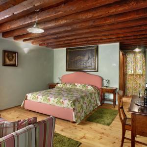 a bedroom with a bed and a wooden ceiling at Tenuta Le Risare in Campo San Martino