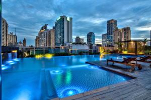 a swimming pool with a city skyline in the background at Radisson Blu Plaza Bangkok in Bangkok