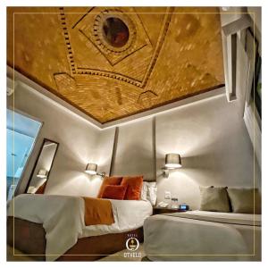 1 dormitorio con 2 camas en una habitación con techo en Othelo Boutique Hotel Mexico en León