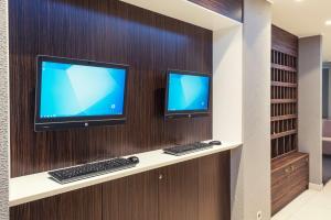 dois monitores de computador numa parede com dois teclados em Park Inn by Radisson Hotel Astana em Astana