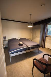 a bedroom with a bed and a chair in it at Klein Cambron in Hulst