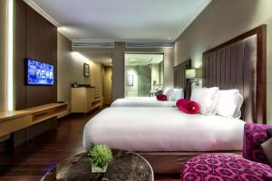 Radisson Blu Plaza Bangkok في بانكوك: غرفة فندق بسرير كبير وتلفزيون