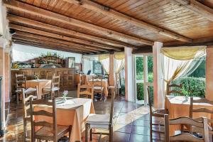 un restaurante con mesas, sillas y ventanas en Colonna Park Hotel en Porto Cervo