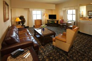 a living room with a brown leather couch and chairs at The Claridge Hotel in Atlantic City