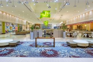 a lobby with tables and chairs in a mall at Radisson Blu Resort Jizan in Jazan