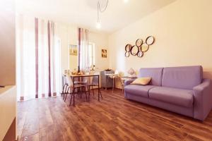 - un salon avec un canapé violet et une table dans l'établissement Dimora Silcla 2, à Polignano a Mare