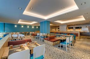 a restaurant with tables and chairs and a bar at Park Inn by Radisson Novokuznetsk in Novokuznetsk