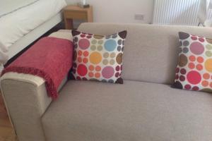 un sofá con almohadas y una manta roja. en Primrose Hill Studio en Londres