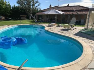 einen Pool mit blauem Wasser im Hof in der Unterkunft Villa Pancorbo in Velayos