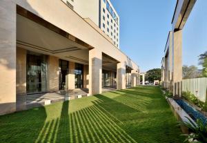 une vue extérieure sur un bâtiment avec une pelouse verte dans l'établissement Radisson Blu Coimbatore, à Coimbatore