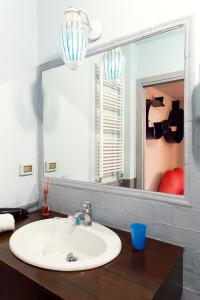 a white sink sitting under a mirror in a bathroom at Suite D'Autore Art Design Gallery in Piazza Armerina