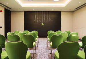 a conference room with green chairs and a screen at Park Inn by Radisson Izmir in İzmir