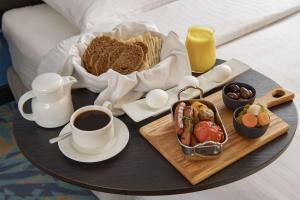 a tray of breakfast foods and coffee on a bed at Park Inn by Radisson Jubail Industrial City in Al Jubail