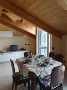 uma mesa de jantar com cadeiras e uma mesa com copos de vinho em Casa da Brunetto em Costarainera
