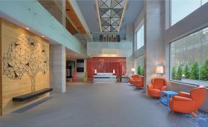 a lobby with orange chairs in a building at Radisson Bengaluru City Center in Bangalore