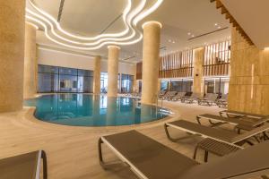 a pool in a hotel lobby with chairs and a ceiling at Radisson Blu Hotel Trabzon in Trabzon