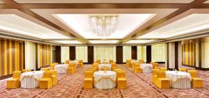 a banquet hall with white tables and yellow chairs at Country Inn & Suites by Radisson Kota in Kota +78 photos