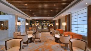 钱德加尔Radisson Chandigarh Zirakpur的酒店大堂设有桌椅和酒吧