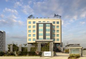 a large white building with a sign in front of it at Radisson Chandigarh Zirakpur in Chandīgarh