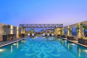 钱德加尔Radisson Chandigarh Zirakpur的建筑物中间的一个大型游泳池