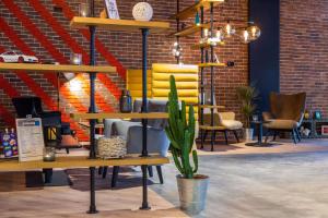 ein Zimmer mit Stühlen, einer Topfpflanze und Regalen in der Unterkunft Park Inn by Radisson Poznan in Posen
