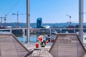 a balcony with two chairs and a table with flowers at Radisson Blu Hotel Bordeaux in Bordeaux