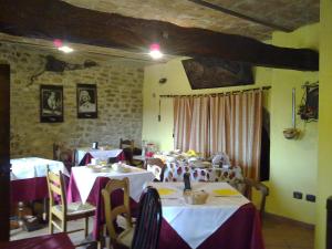 un comedor con mesas y sillas con mantel blanco en Arco Dei Nobili, en Monforte dʼAlba