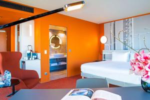 a bedroom with orange walls and a bed and a table at Radisson Blu Hotel Bordeaux in Bordeaux