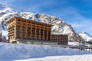安德馬特的住宿－Radisson Blu Hotel Reussen, Andermatt，雪覆盖的山前的建筑物