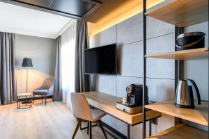 アントワープにあるRadisson Hotel Antwerp Berchemのテーブルとテレビが備わる客室です。