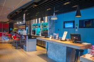 a restaurant with a counter and a bar with stools at ibis Montenegro in Montenegro