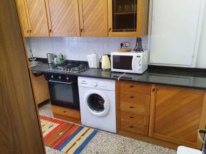 een keuken met een wasmachine en een magnetron bij Violetta Portofino by PortofinoVacanze in Rapallo
