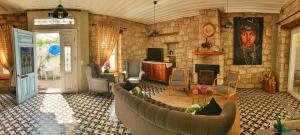 a living room with a couch and a stone wall at Maison d'Azur Alaçatı in Alacati