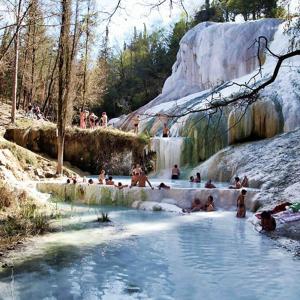 un grupo de personas en una piscina en una cascada en B&B Locanda Sant'Antimo, en Montalcino