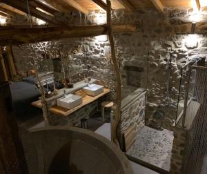 uma casa de banho com 2 lavatórios e uma parede de pedra em Magic Mill Castagnetoli em Mulazzo